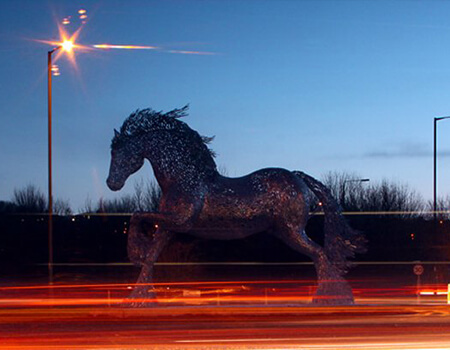 horse sculpture on a roundabout with floodlights